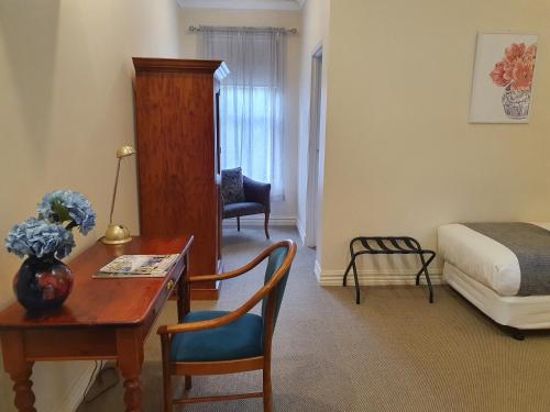 a room with a desk and a bedroom with a bed at The Lancefield Lodge in Lancefield