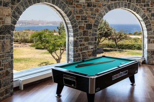 a pool table in front of a window with a view at Kouros Exclusive Hotel & Suites - Adults Only in Faliraki