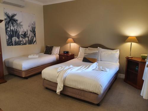 a hotel room with two beds with white sheets at The Lancefield Lodge in Lancefield