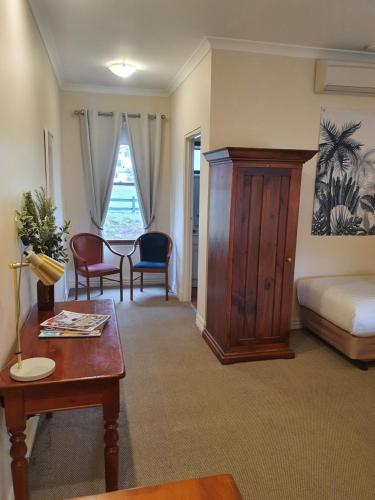 a living room with a bed and a table and a table sidx sidx at The Lancefield Lodge in Lancefield