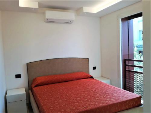 um quarto com uma cama com um cobertor vermelho em Villa Cisa con yacuzzi em Lignano Sabbiadoro