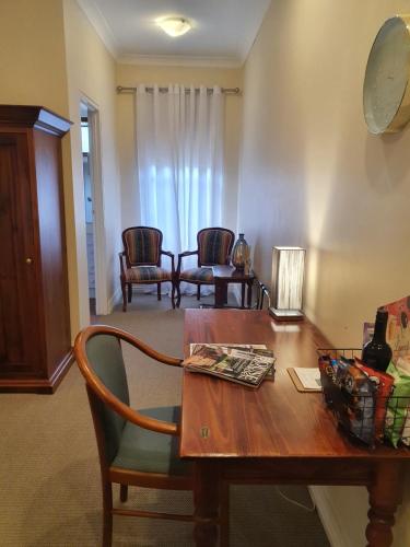 a living room with a wooden table and chairs at The Lancefield Lodge in Lancefield