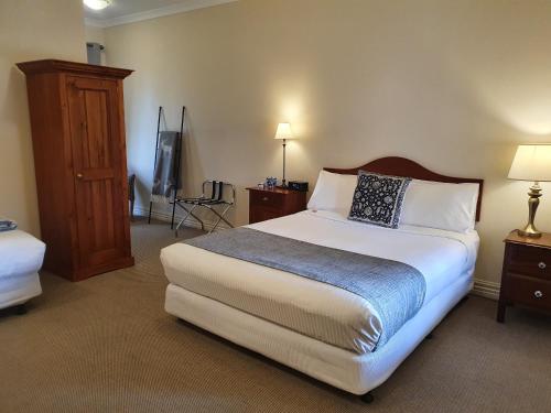 a hotel room with a bed and a tv at The Lancefield Lodge in Lancefield