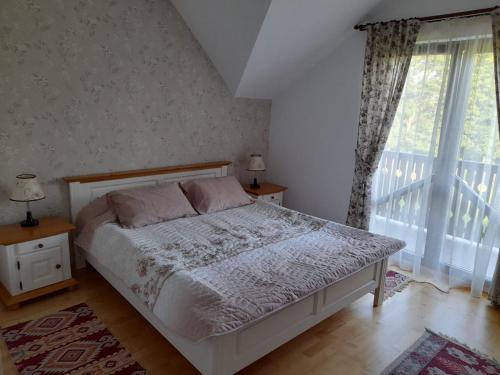 a bedroom with a bed with two tables and a window at Pensiunea Obcina Mare in Cacica