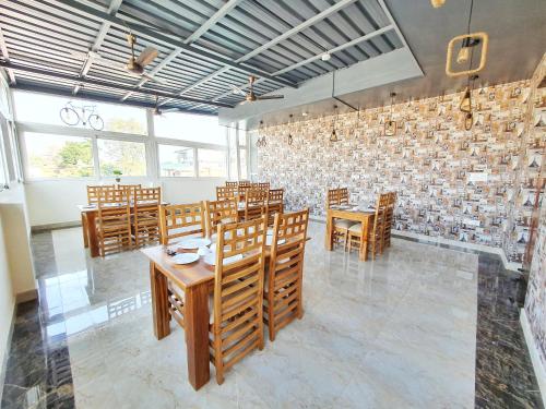 a dining room with wooden tables and chairs at The Park Residency in Dehradun