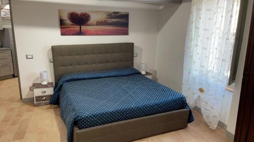 a bedroom with a bed and a painting on the wall at Appartamento LA FINESTRELLA in Città della Pieve