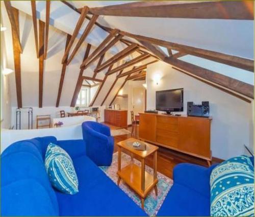 uma sala de estar com um sofá azul e uma televisão em Apartments Vi-La em Dubrovnik