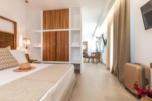 Una habitación de hotel con una cama y una sala de estar. en Apleton Suites, en Agia Anna de Naxos