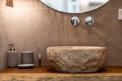 y baño con lavabo de mármol grande y espejo. en Apleton Suites, en Agia Anna de Naxos