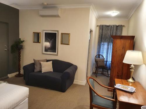 a living room with a couch and a table at The Lancefield Lodge in Lancefield