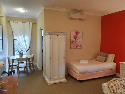 a bedroom with a bed and a table and a dining room at The Lancefield Lodge in Lancefield