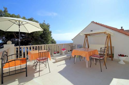 un patio con mesa, sillas y sombrilla en Rooms&Studios Rina, en Dubrovnik