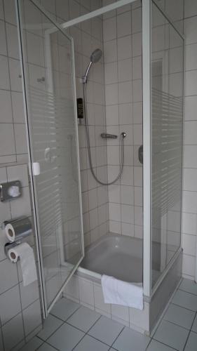 a bathroom with a shower and a bath tub at Hotel Landhaus Greene in Einbeck