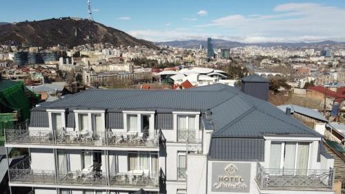 a house with a black roof and a city at MariaLuis Hotel in Tbilisi City