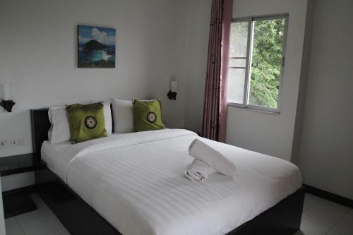 - une chambre avec un grand lit blanc et une fenêtre dans l'établissement The CK Residence Pattaya, à Pattaya