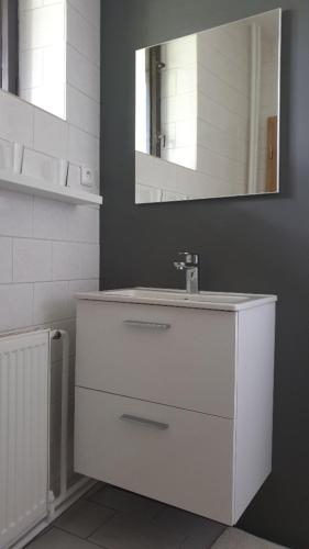 a white bathroom with a sink and a mirror at Penzion Eden Turnov in Turnov