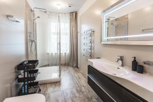 uma casa de banho com um lavatório, um chuveiro e uma banheira em Riga Lux Apartments - Skolas em Riga