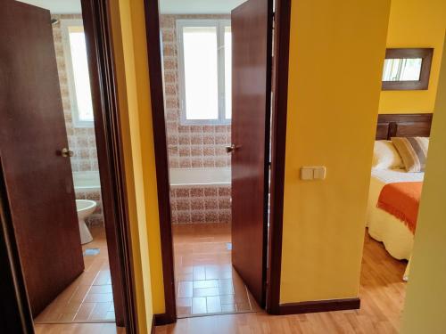 a room with a bathroom and a bedroom with a bed at ACT RIOCOBO in Cervo