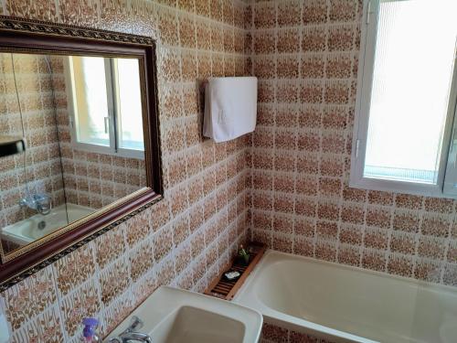 a bathroom with a tub and a sink and a mirror at ACT RIOCOBO in Cervo
