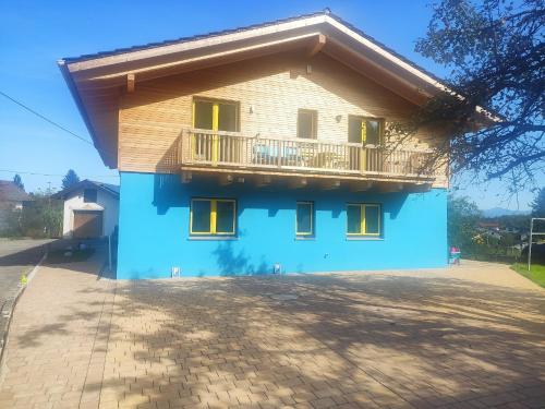 a blue house with a balcony on top of it at Ferienwohnungen Graßmann in Piding