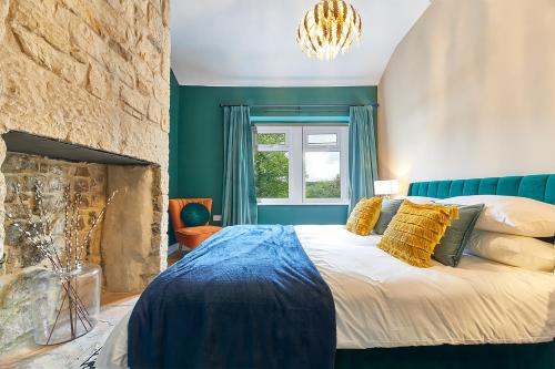 1 dormitorio con 1 cama grande y chimenea en Host & Stay - Percy Cottage, en Otterburn