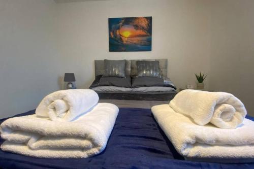 uma sala de estar com duas cadeiras brancas e uma cama em The Onyx Suite - 1 Bed apartment w/ free parking em Cardiff