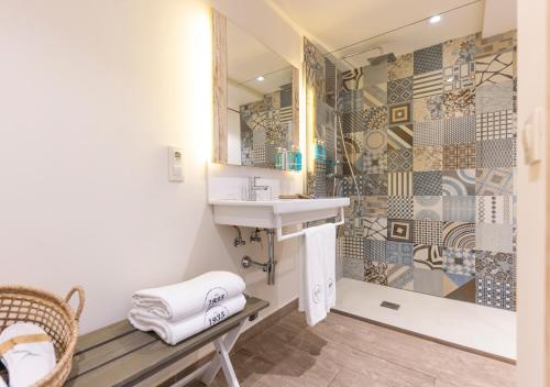 La salle de bains est pourvue d'un lavabo et d'une douche. dans l'établissement 1935 Hotel Boutique by Terraza, à Roses