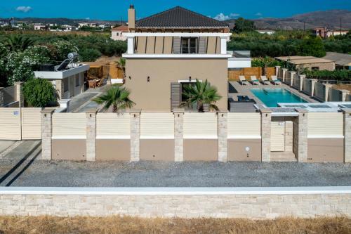 a house with a fence and a swimming pool at Villa Persephone in Tavronitis
