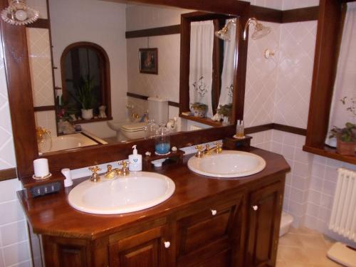 a bathroom with two sinks and a large mirror at Les Hirondelles in Fenis