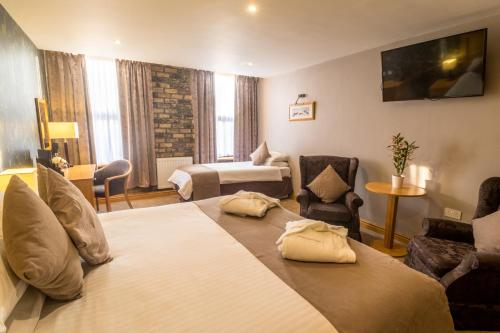 a hotel room with two beds and a bedroom at Washington Central Hotel and Sleepwell Inn in Workington