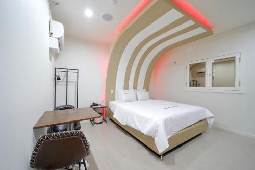Schlafzimmer mit einem Bett und einem Holztisch in der Unterkunft HOTEL ViA in Ansan