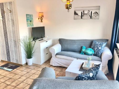 a living room with a couch and a tv at Apartments Zur schönen Aussicht in Büsum