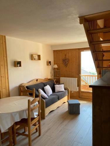 ein Wohnzimmer mit einem Sofa und einem Tisch in der Unterkunft Les sybelles in La Chal