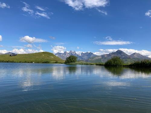 uma vista para um lago com montanhas ao fundo em Les sybelles em La Chal