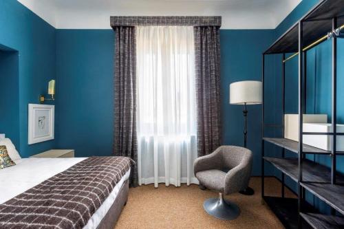 フィレンツェにある4F Boutique Hotel Florenceのベッドルーム1室(ベッド1台、椅子、窓付)