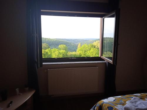 Schlafzimmer mit einem Fenster mit Blick auf die Bäume in der Unterkunft La Maison de Heidi in Hazelbourg