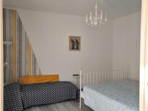 a bedroom with a bed and a chandelier at CasAgnese Sanremo in Sanremo