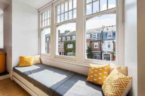 asiento junto a la ventana en una habitación con ventana grande en Luxury Apartment in Belsize Park en Londres