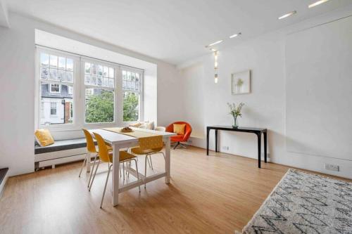 a white living room with a table and chairs at Luxury Apartment in Belsize Park in London