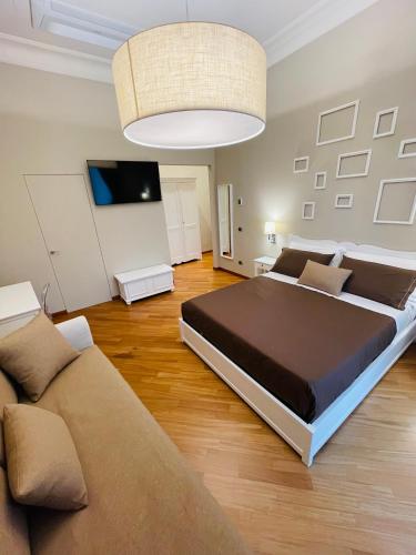 a bedroom with a large bed and a couch at L’Arco Bed&Breakfast in Avigliano