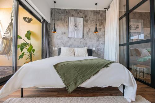 a bedroom with a large white bed with a concrete wall at Seguros House - Charming Flat in Cascais
