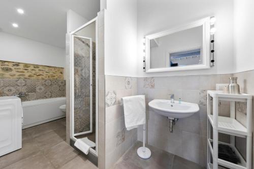 La salle de bains blanche est pourvue d'un lavabo et d'un miroir. dans l'établissement Teatro della Pergola Apartment, à Florence