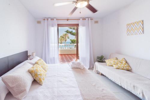 a living room with a couch and a ceiling fan at Expoholidays-Chalet Bahari primera linea de playa in Roquetas de Mar