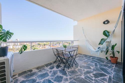 a room with a hammock and a table and chairs at Seguros House - Charming Flat in Cascais