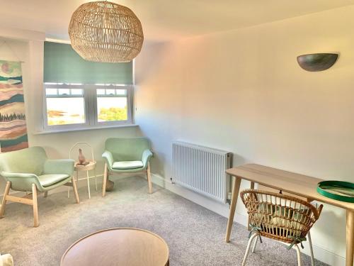 a living room with chairs and a table at SkyView Eastbourne 24 in Eastbourne