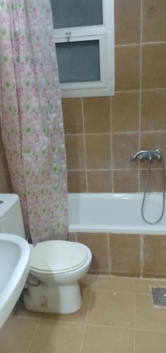 a bathroom with a toilet and a shower curtain at Amazing Chalet North Coast Egypt in Dawwār ‘Abd Allāh
