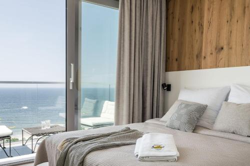 a bedroom with a bed with a view of the ocean at Apartamenty Balticus SeaView by Rent like home in Międzyzdroje
