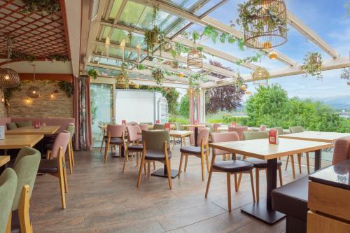 ein Restaurant mit Tischen und Stühlen und einer Glasdecke in der Unterkunft Hotel San Marco in Füssen
