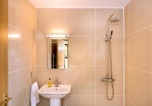 ein Bad mit einem Waschbecken und einer Dusche mit einem Waschbecken in der Unterkunft The Studio with Terrace Kelly Bray Cornwall in the Tamar Valley in Callington