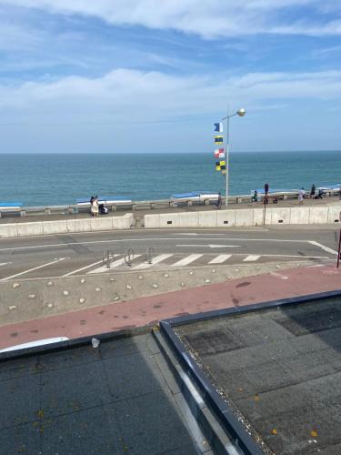 a street with a traffic light next to the ocean at New Hôtel de la Mer in Fécamp